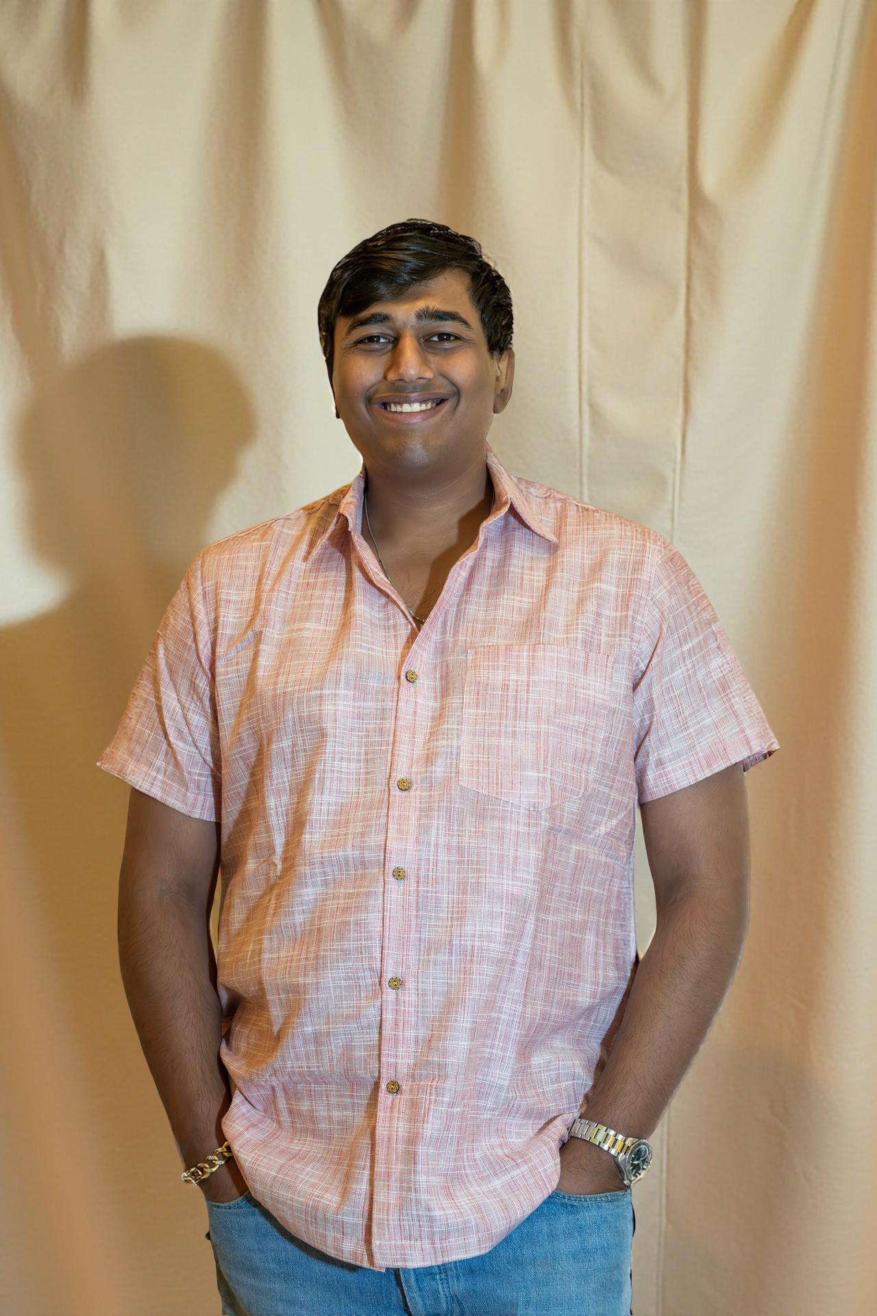 Model wearing a half-sleeve handwoven cotton shirt in rose grid pattern, sustainably made from 100% breathable cotton, perfect for summer.