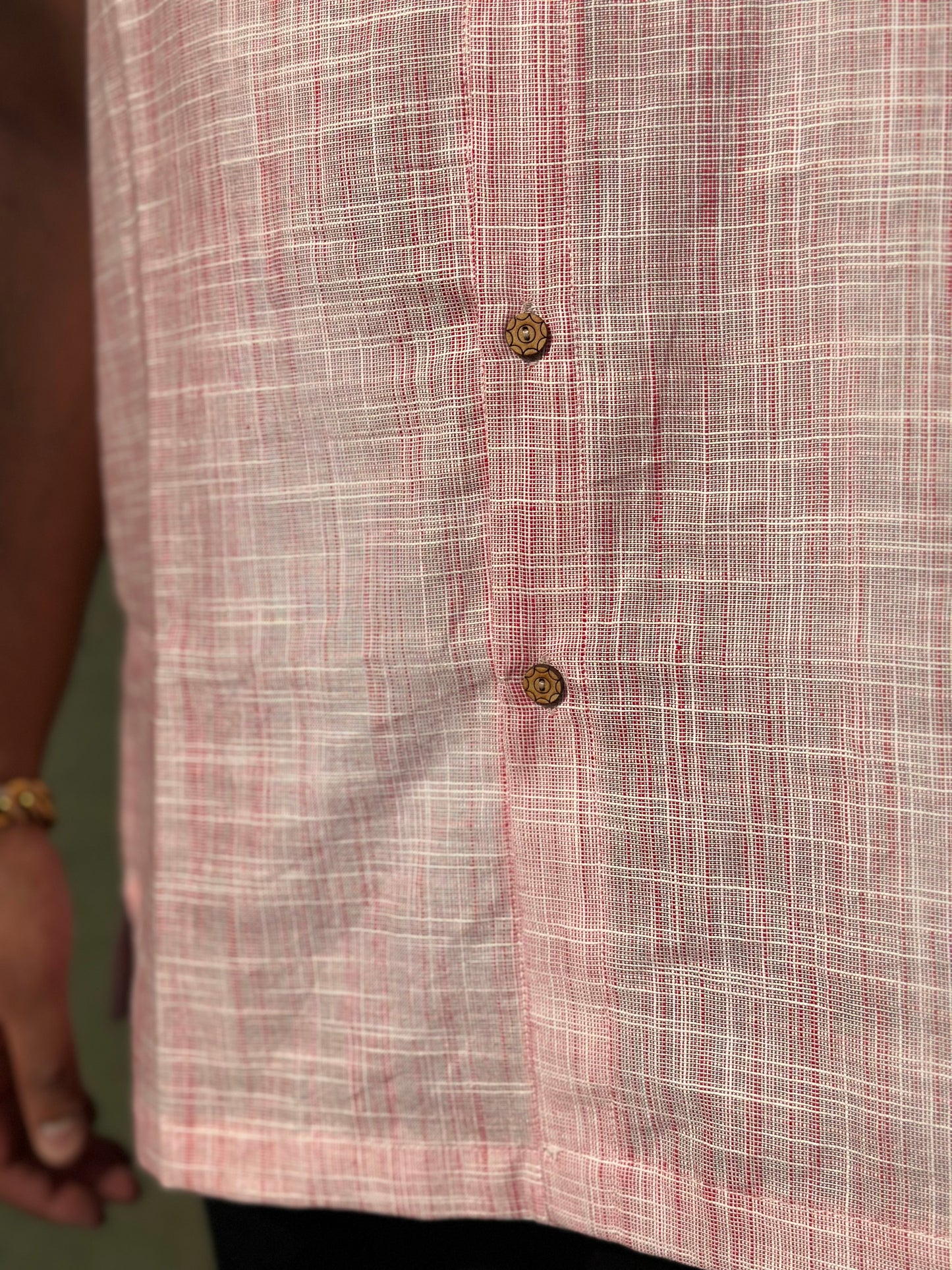 A close up photo of the pattern, the coconut buttons and the length of the shirt. 