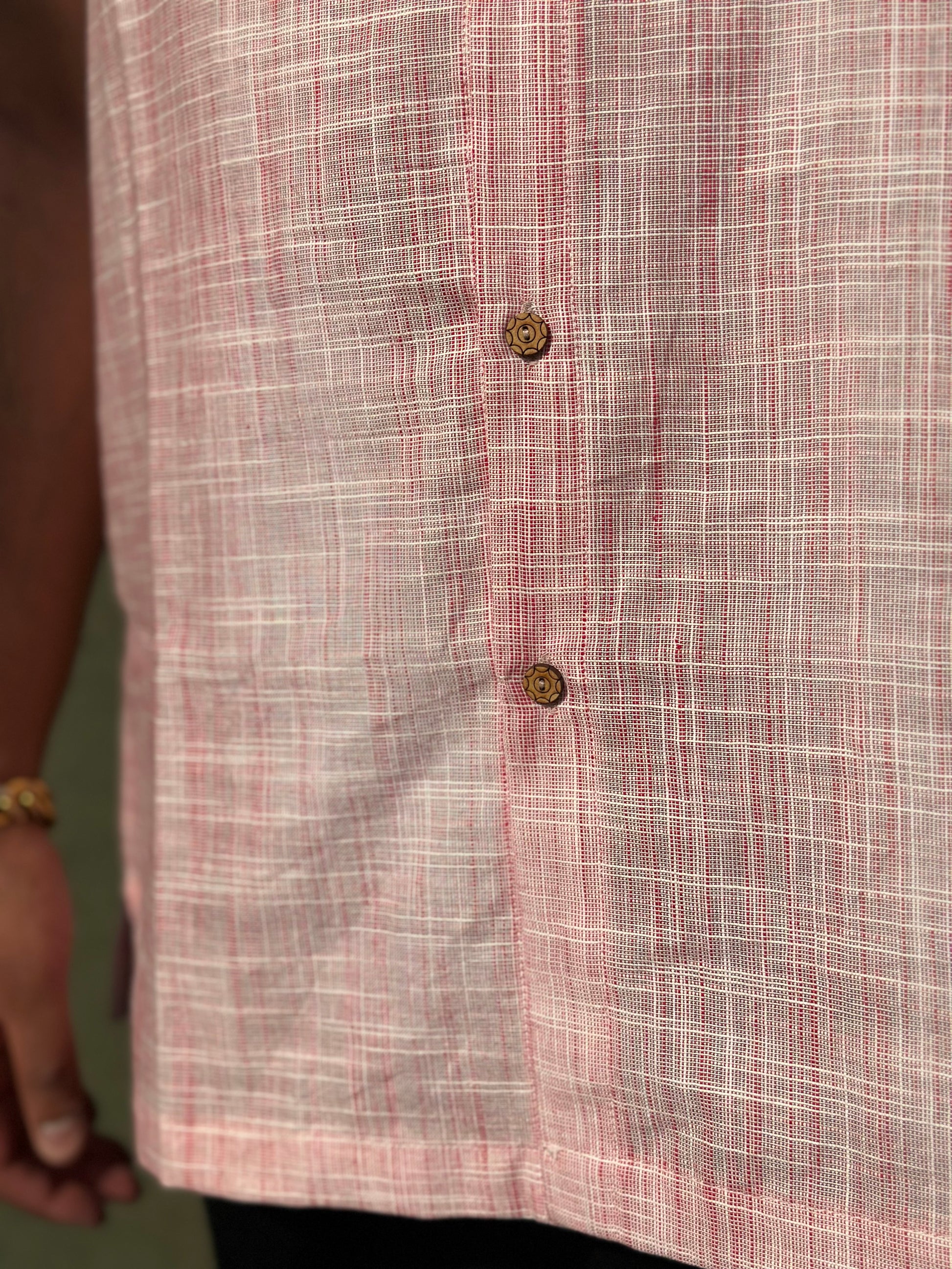 A close up photo of the pattern, the coconut buttons and the length of the shirt. 